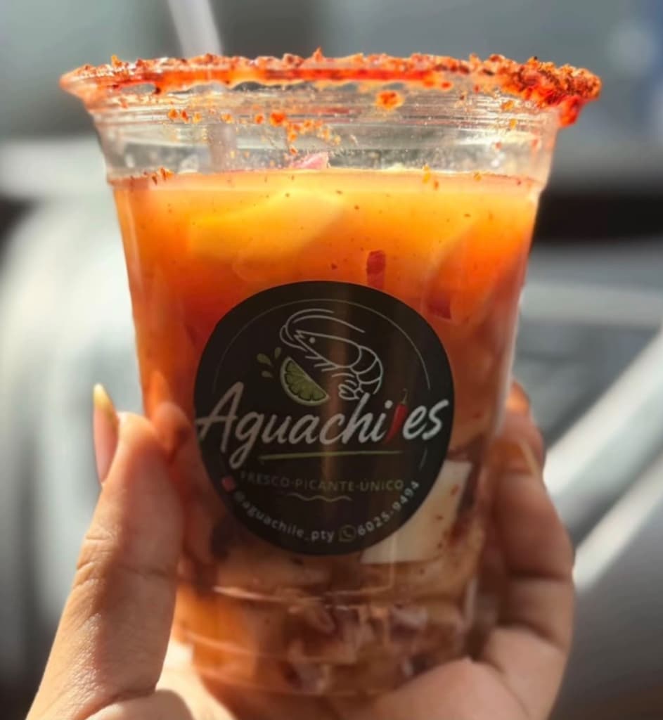 Vaso de aguachiles con el borde escarchado de chamoy y tajín y la etiqueta de Aguachiles